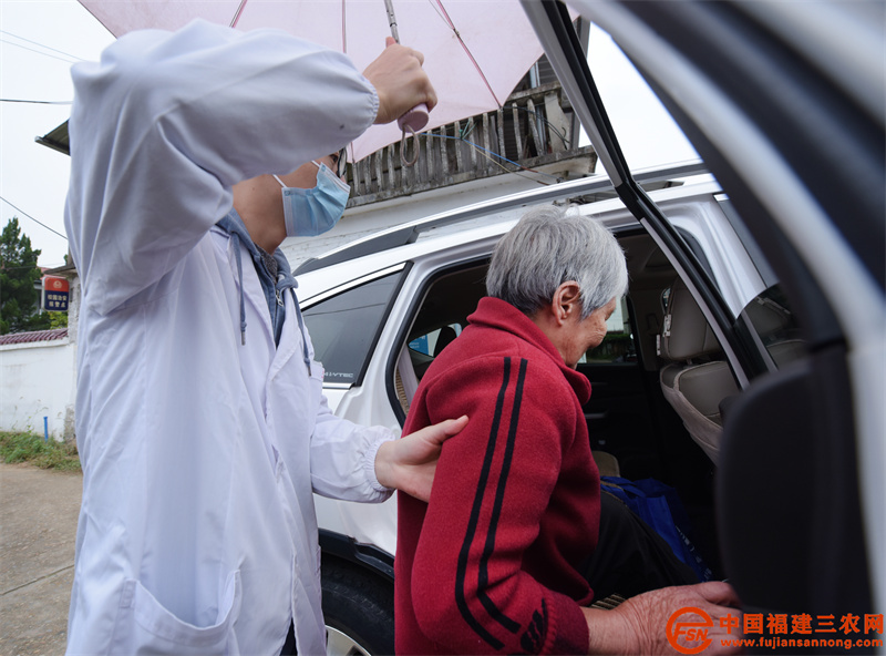 下雨天,连佳乐为看完病的老人撑伞送上车。.jpg