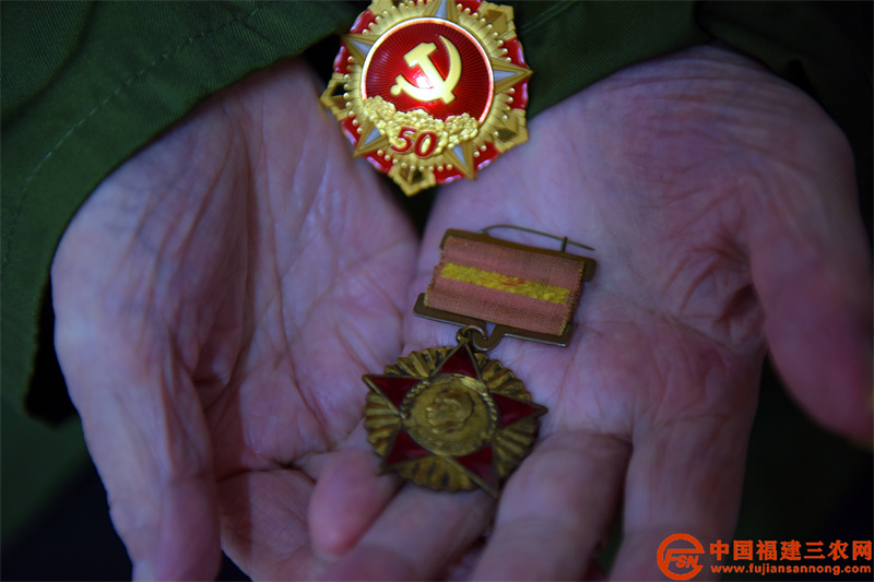 每一个勋章都是老人最贵重的宝贝,叶乌伢轻轻地捧在手心。(黄杰敏 摄).jpg